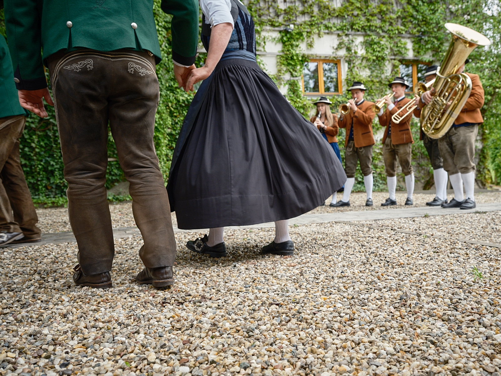 Tanzende Menschen in Tracht mit Volksmusikern