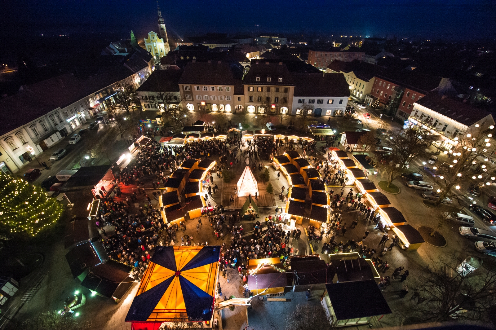 Vogelperspektive: Weihnachtsmarkt am Hauptplatz in Fürstenfeld, abendliche Stimmung mit Hütten und Lichtern