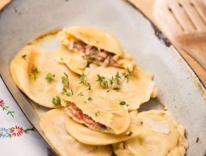 mehrere Nudeltascherl, eines davon aufgeschnitten, mit Thunfischfülle auf länglichem Teller