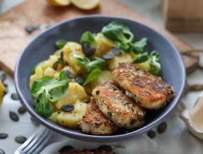 gebackene Halloumischeiben mit Kürbiskernpanade, dazu Erdäpfel-Vogerlsalat, alles in tiefem, blauem Teller