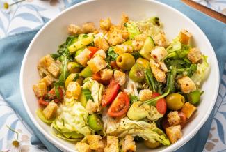 Brotsalat mit Rucola, Paradeisern, Oliven und Frühlingszwiebeln