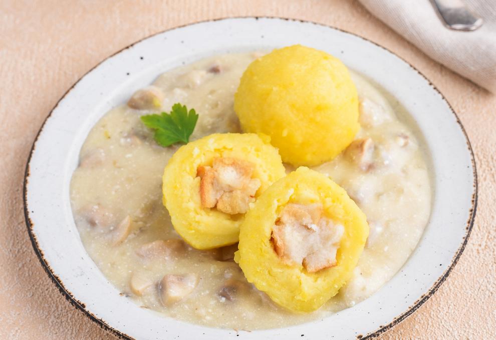 Erdäpfelknödel mit Semmelwürfelfülle in Pilzsauce