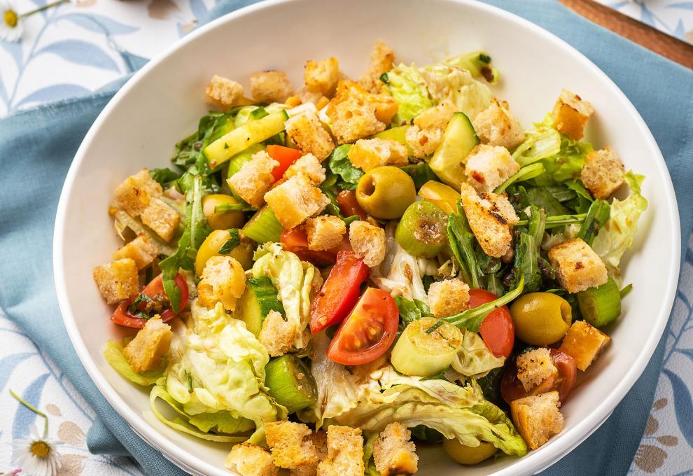 Brotsalat mit Rucola, Paradeisern, Oliven und Frühlingszwiebeln