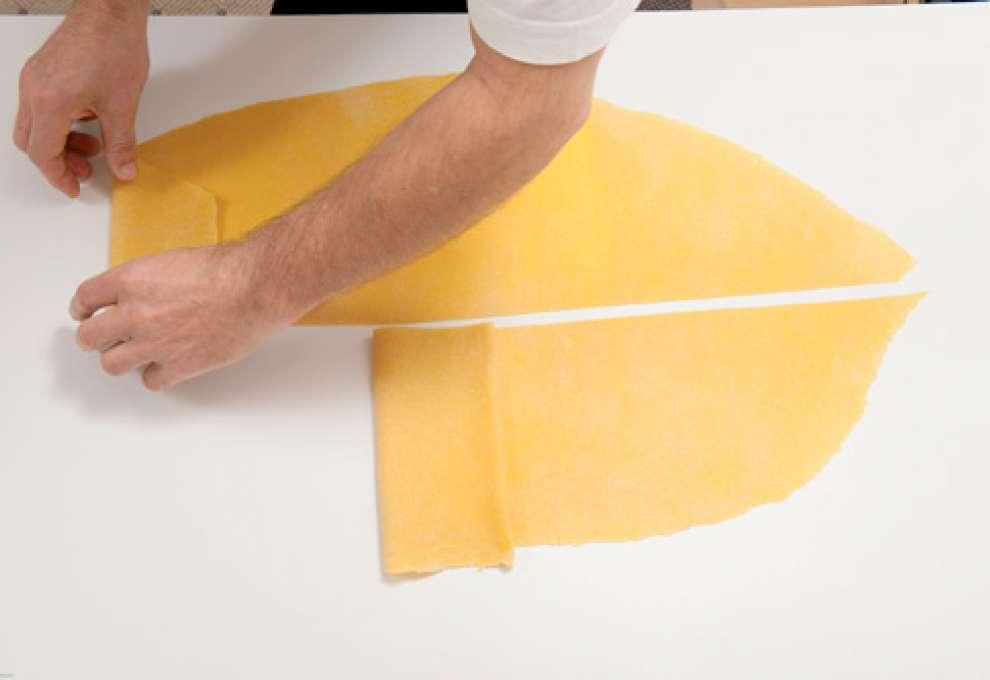 Teigplatte wird in Streifen geschnitten