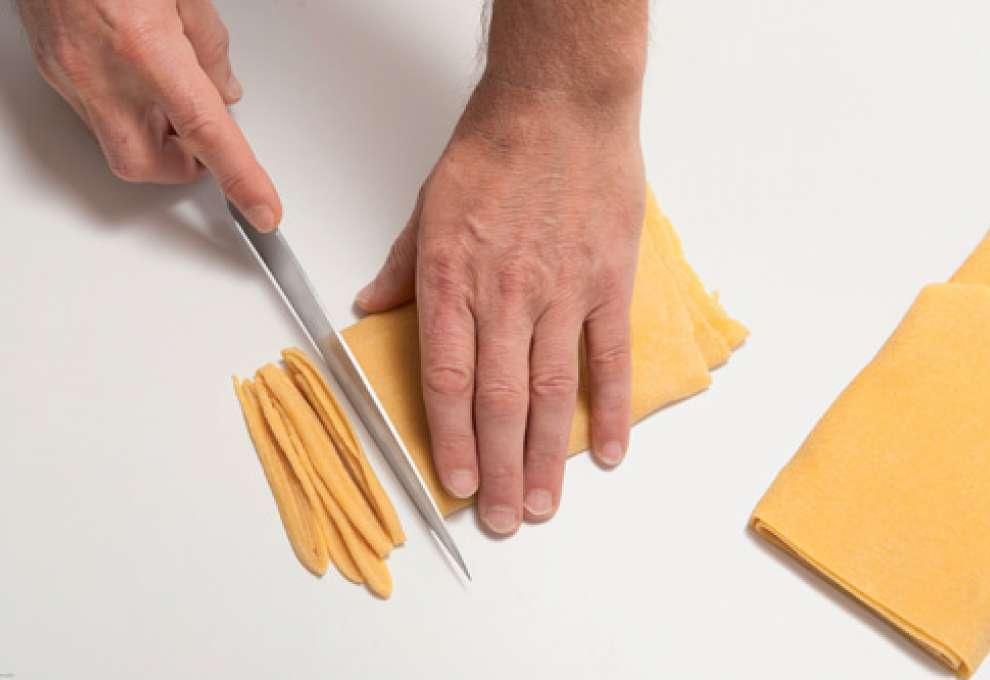 Teigplatte wird in Streifen geschnitten