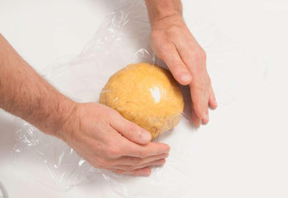 Teigkugel wird in Frischhaltefolie eingeschlagen