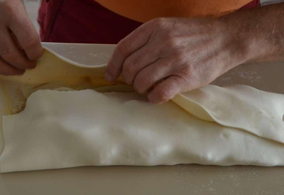 Blätterteigstrudel wird eingerollt.