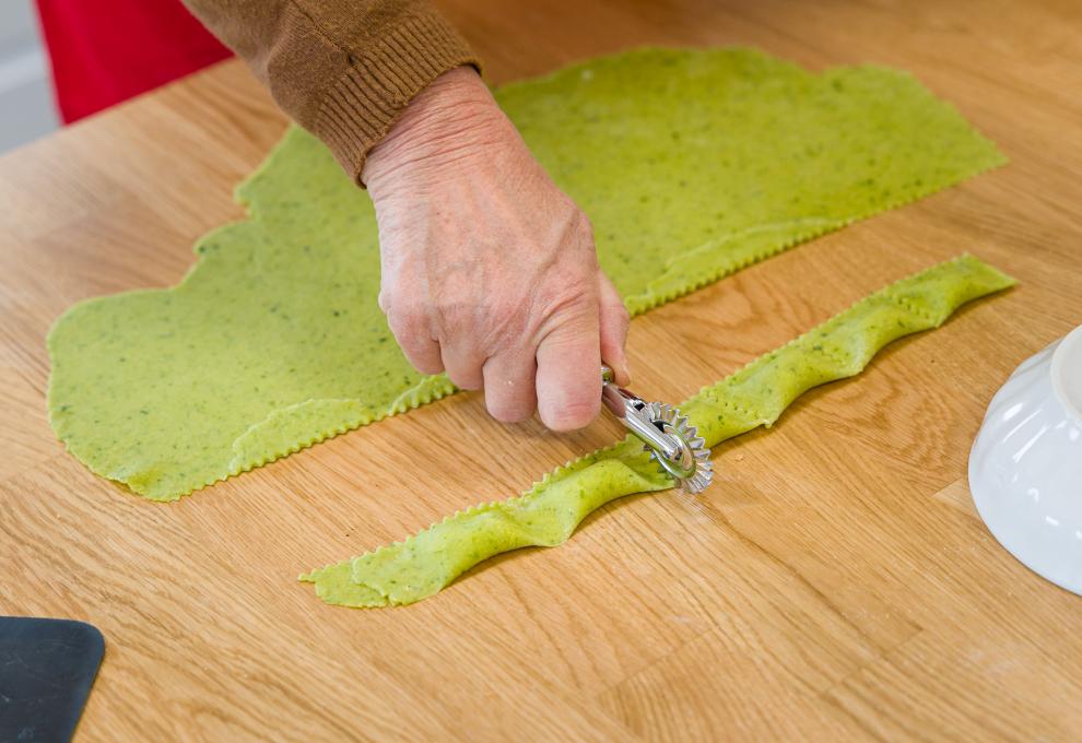 Grüne Ravioli aus Bärlauchnudeln – zuerst Fülle auftragen, dann falten, zudrücken und zuletzt schneiden. 