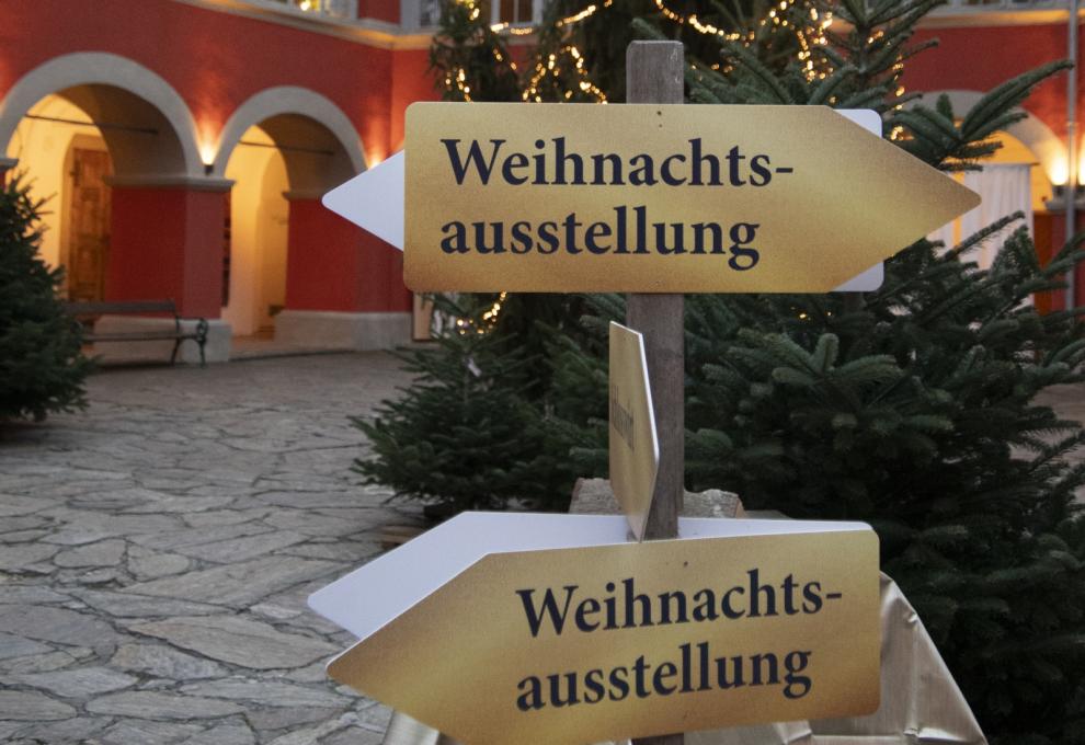 Wegweiser Weihnachtsausstellung in weihnachtlich geschmücktem Innenhof