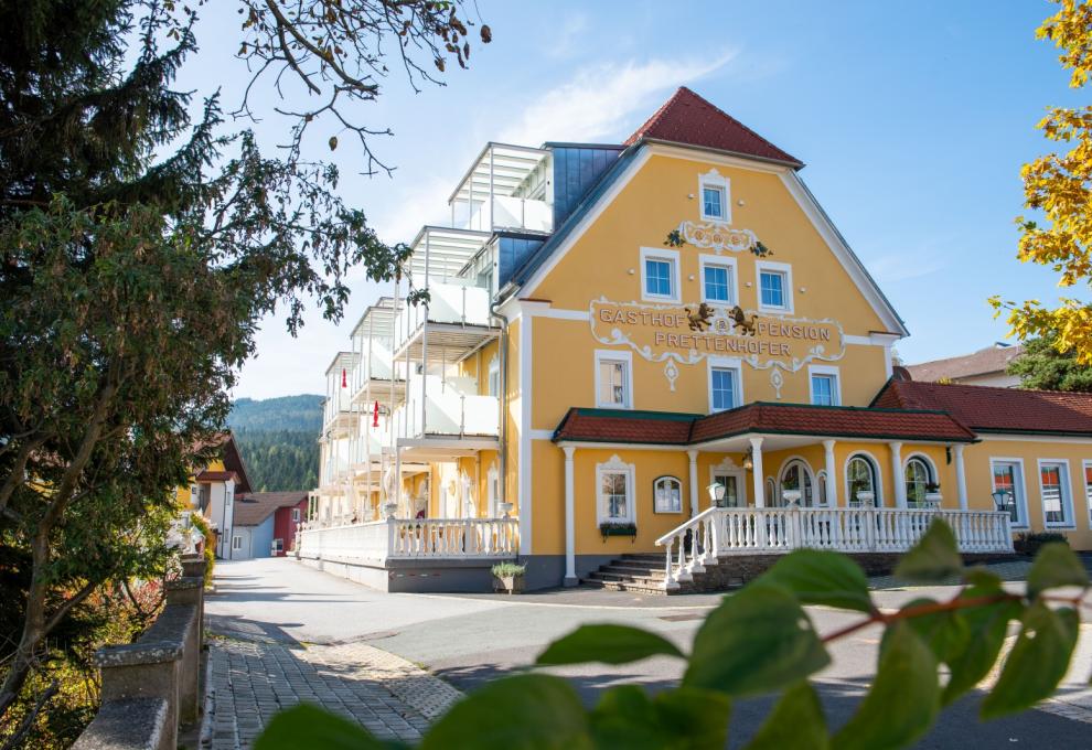 Außenansicht Hotel mit gelber Fassade und Aufschrift Gasthof Pension Prettenhofer