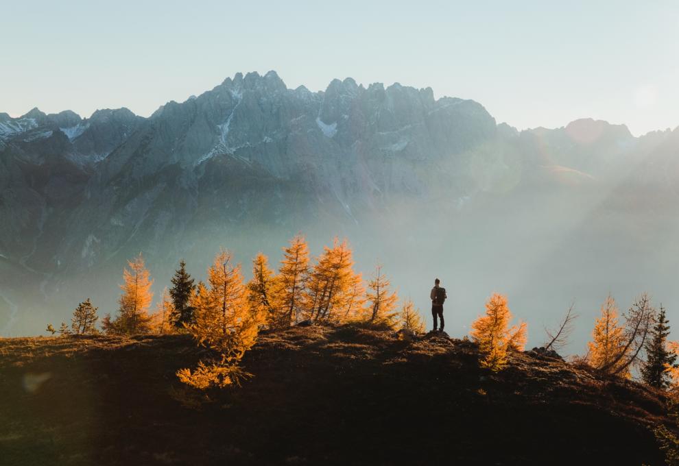 Wanderer in Herbststimmung vor hohen Bergen