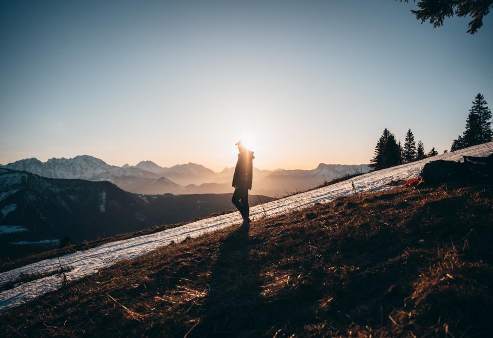 Wanderer auf schneebedecktem Feld, Abendstimmung mit Wintersonne
