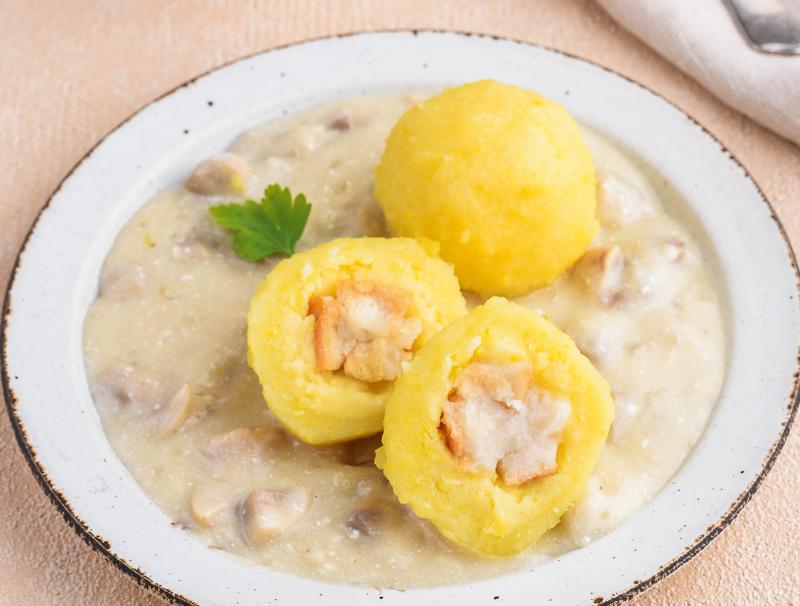 Erdäpfelknödel mit Semmelwürfelfülle in Pilzsauce