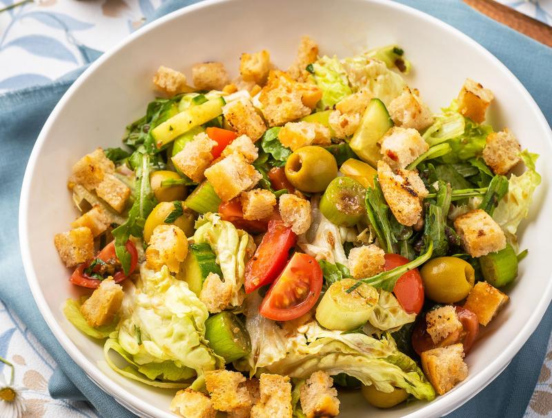 Brotsalat mit Rucola, Paradeisern, Oliven und Frühlingszwiebeln