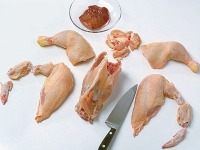 2. Mit einem scharfen Messer auf einer Arbeitsfläche das Huhn tranchieren: Keulen, Brust und Flügerln vom Korpus trennen. 