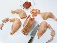 2. Mit einem scharfen Messer auf einer Arbeitsfläche das Huhn tranchieren: Keulen, Brust und Flügerln vom Korpus trennen. 
